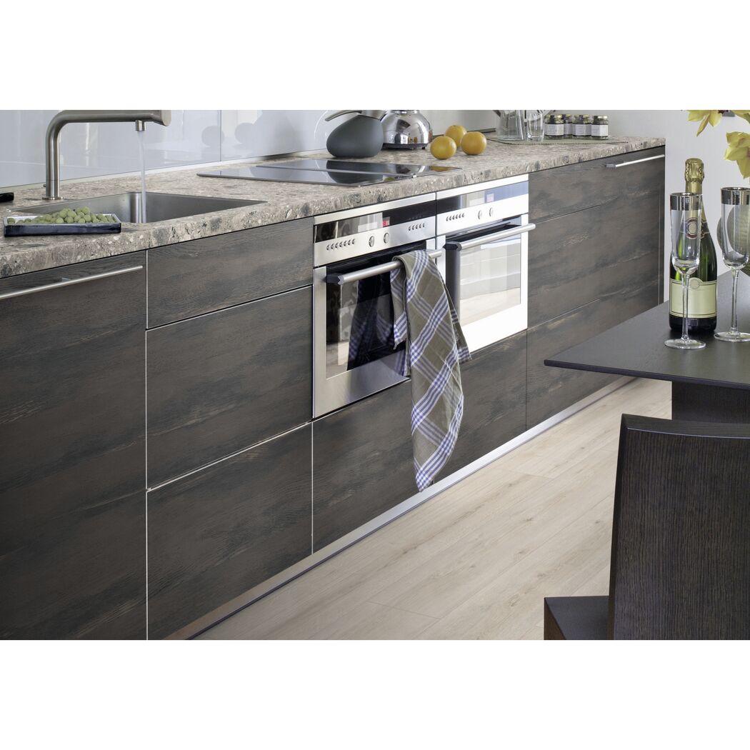 Moderne Küche mit dunklen Schränken und Backofen.