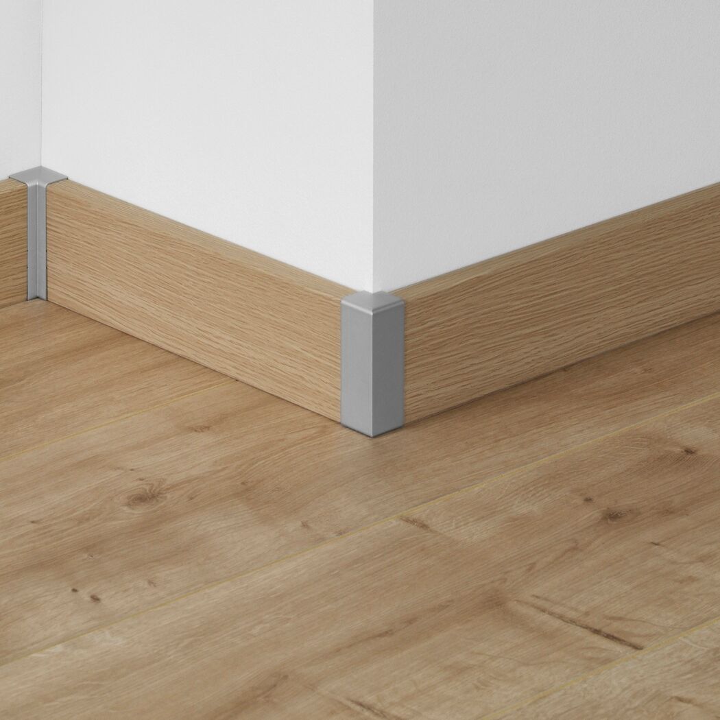 Ecke einer Holzfußleiste mit Alu-Aussenecke