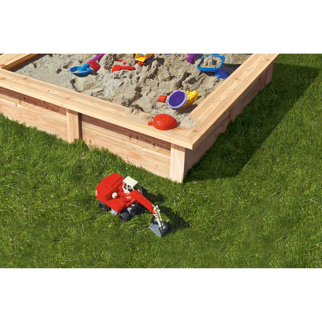 Hölzerner Sandkasten mit Spielzeugbagger und Sandspielzeug