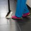 Person wischt mit Dampfreiniger Fliesen