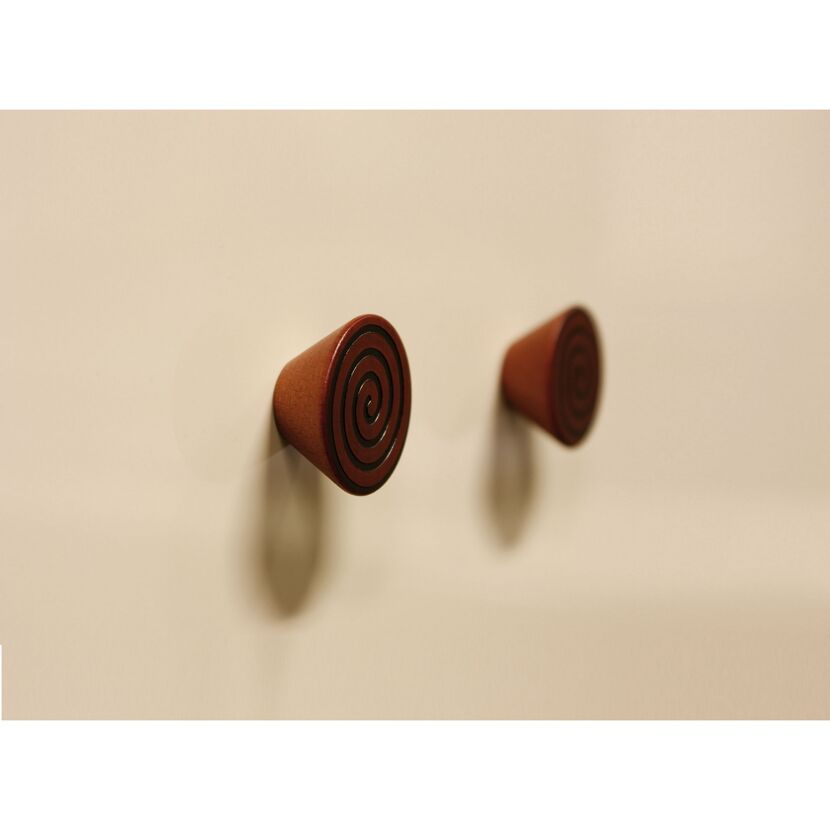 Zwei rote Möbelknöpfe mit Spiralmuster.