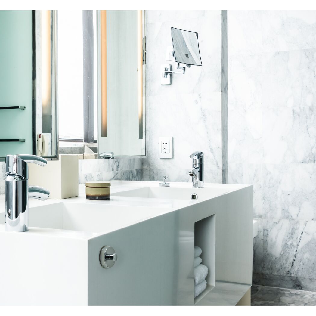Waschbecken mit zwei Wasserhähnen und Handtüchern