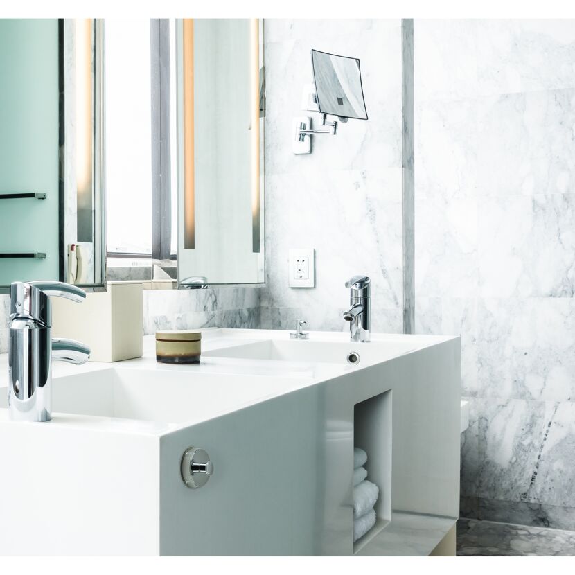 Waschbecken mit zwei Wasserhähnen und Handtüchern