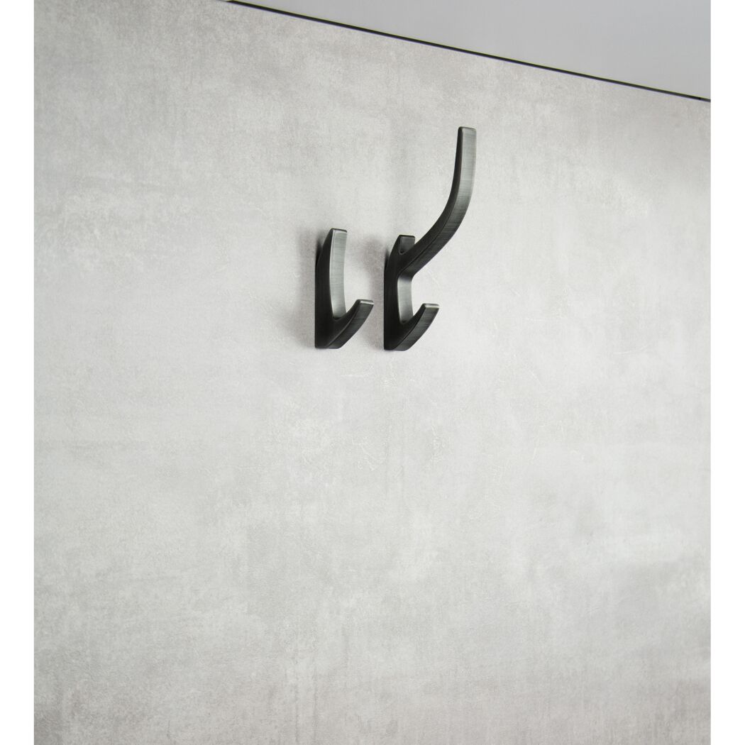 Zwei schwarze Kleiderhaken an einer Wand.