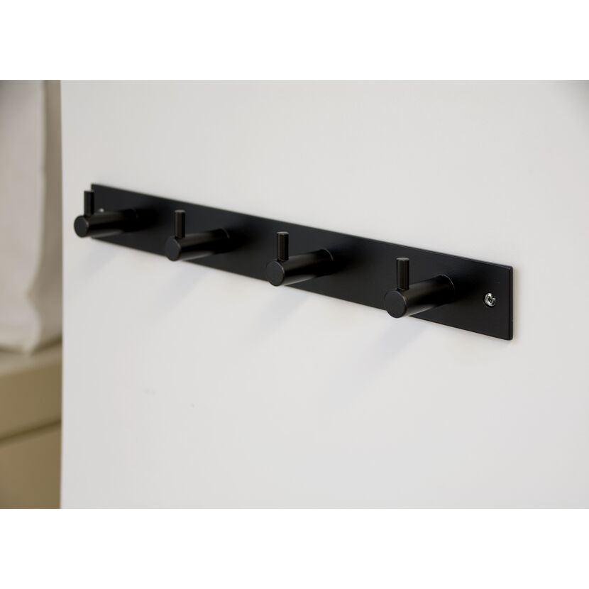 Schwarze Hakenleiste mit vier Haken an einer weißen Wand.