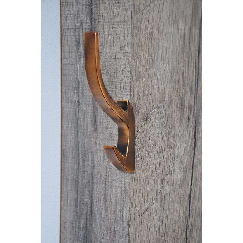 Messingfarbener Haken an Holzwand