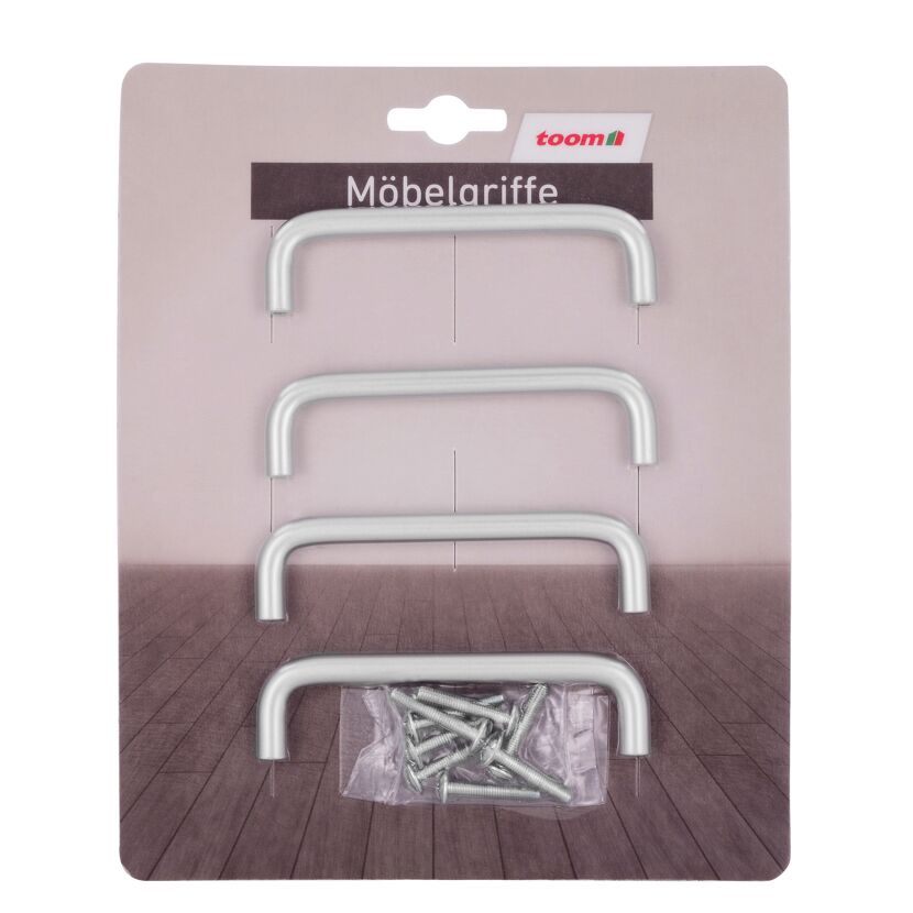 Vier silberne Möbelgriffe und Schrauben in einer Verpackung.