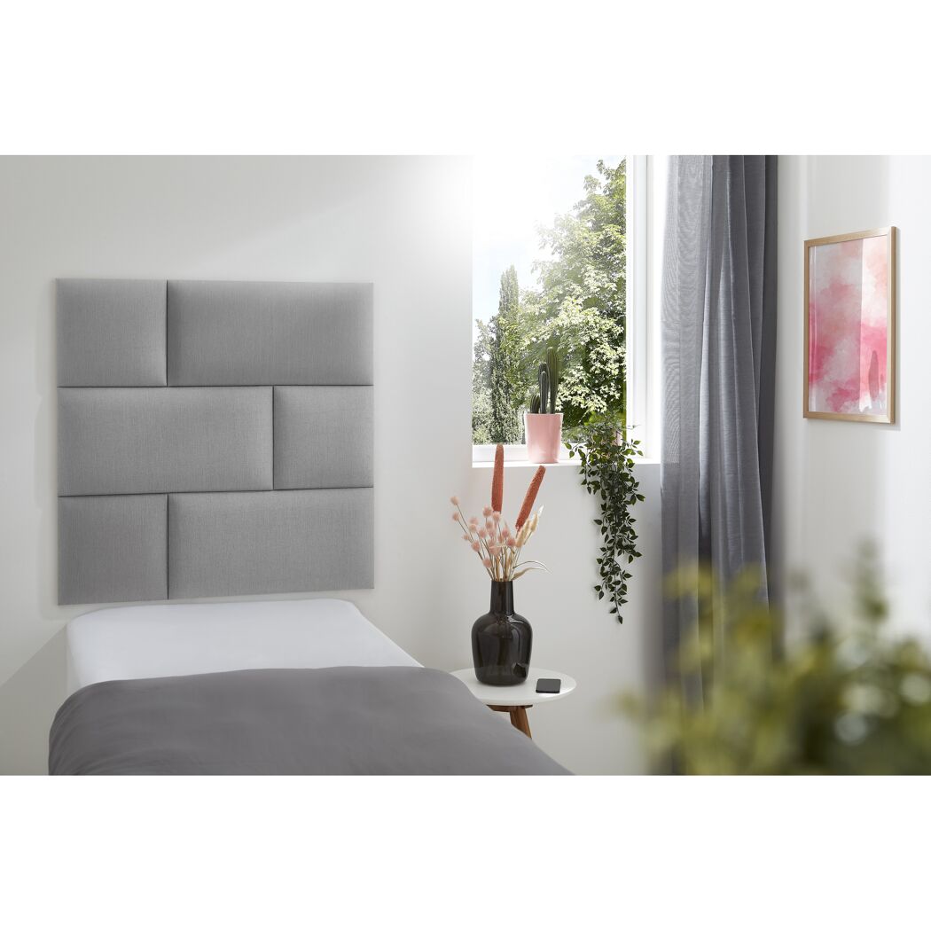 Graues Wandkissen Inari an einem Bett