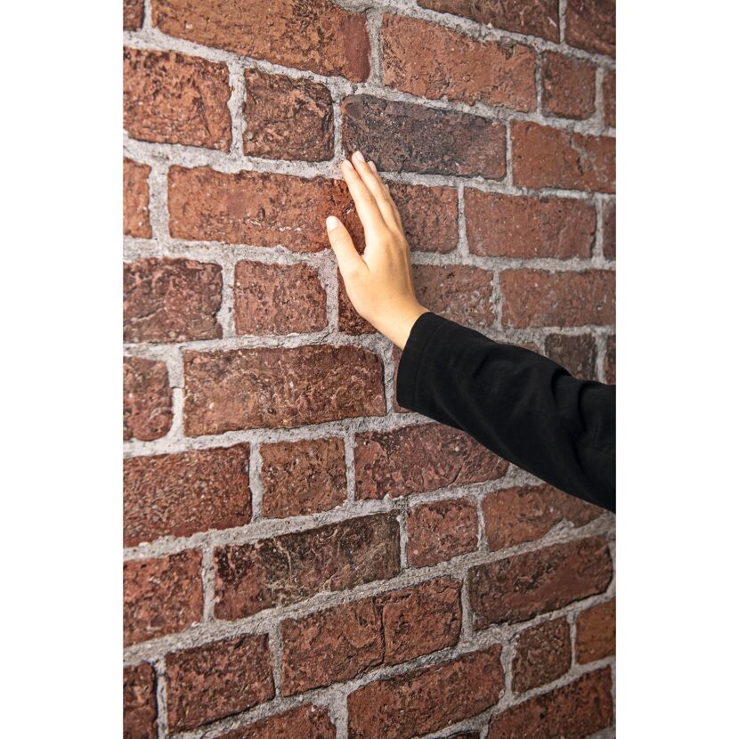 Hand berührt Ziegelwand