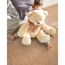 Kind sitzt auf Korkboden und kuschelt mit großem Teddybären.
