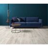 Blaues Sofa und Beistelltische auf hellem Laminatboden.
