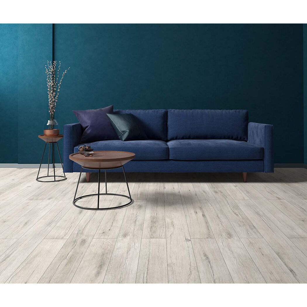 Blaues Sofa und Beistelltische auf hellem Laminatboden.