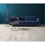 Blaues Sofa und Beistelltische auf hellem Laminatboden.