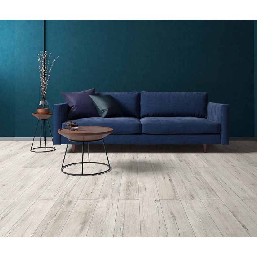 Blaues Sofa und Beistelltische auf hellem Laminatboden.