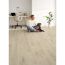 Person sitzt mit Hund auf Designboden Oak Taupe Corklife