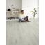 Person sitzt mit Hund auf Designboden Oak Silver Corklife
