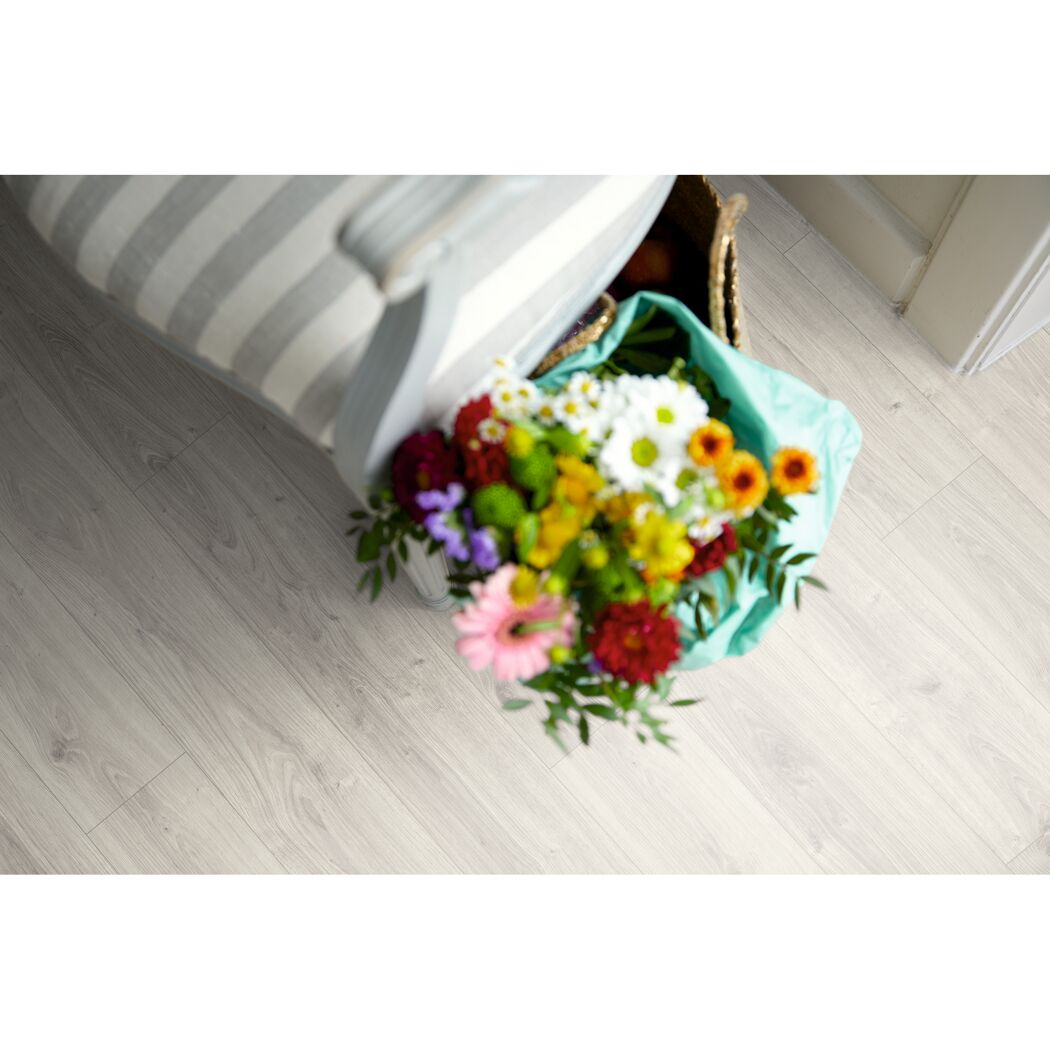 Heller Laminatboden, daneben ein Blumenstrauß und ein Sessel