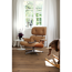 Wohnzimmer mit braunem Laminatboden, Ledersessel und Schaukelpferd