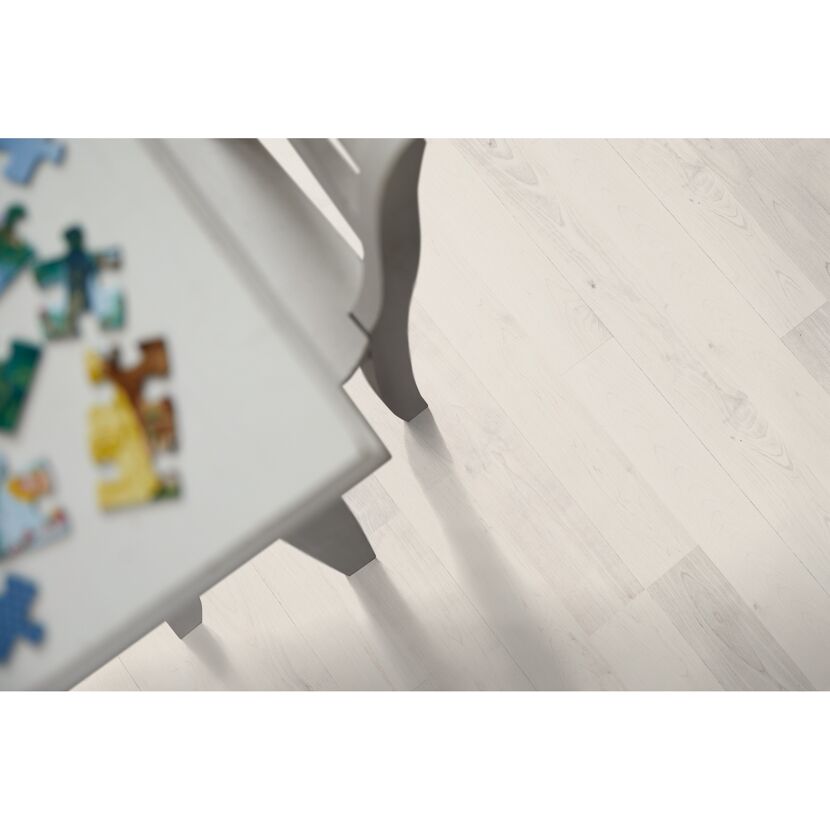 Weißer Laminatboden, auf dem ein Puzzle liegt.
