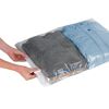 Person verschließt einen Vakuumbeutel mit Kleidung.