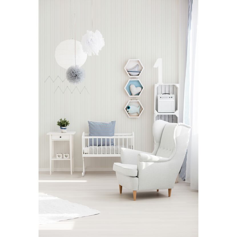Weißes Babyzimmer mit Kinderbett und Sessel.