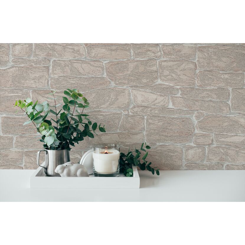 Kerze, Eukalyptus und Hase auf einem Tablett vor einer Steinwand