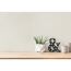 Holztisch mit Pflanze und Deko vor beiger Wand