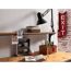 Schreibtisch mit Lampe, Notizbuch und Wandregal