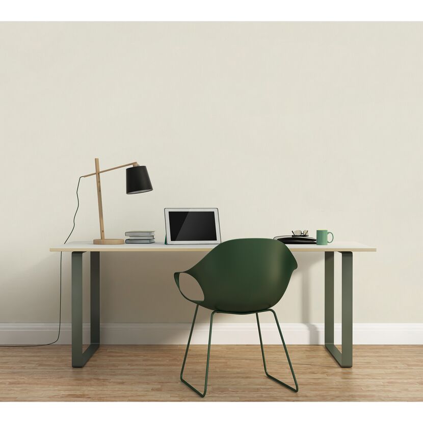 Schreibtisch mit Laptop, Lampe und grünem Stuhl