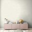 Wohnzimmer mit roséfarbenem Sideboard und beiger Wand