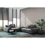 Wohnzimmer mit grauer Couch, Couchtisch und Pflanze
