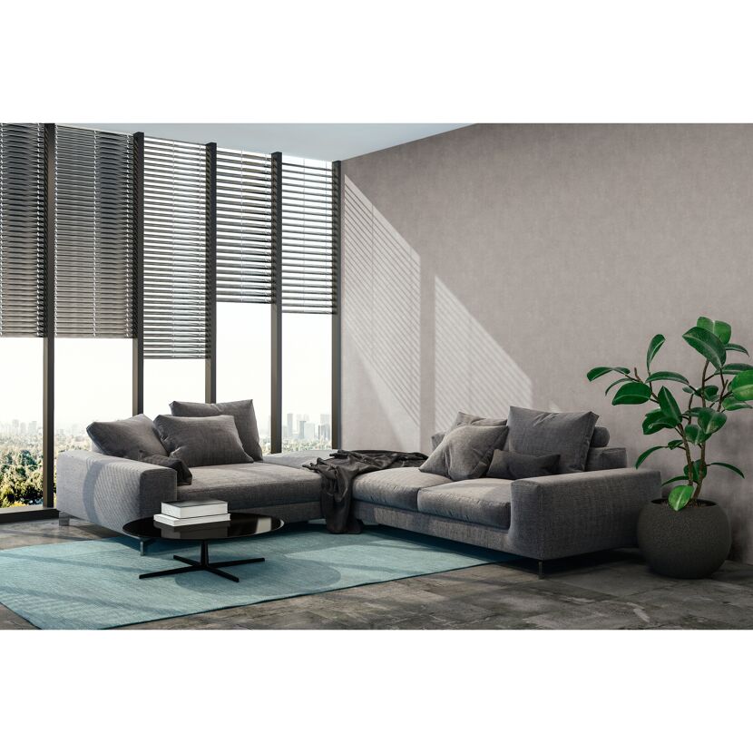 Wohnzimmer mit grauer Couch, Couchtisch und Pflanze