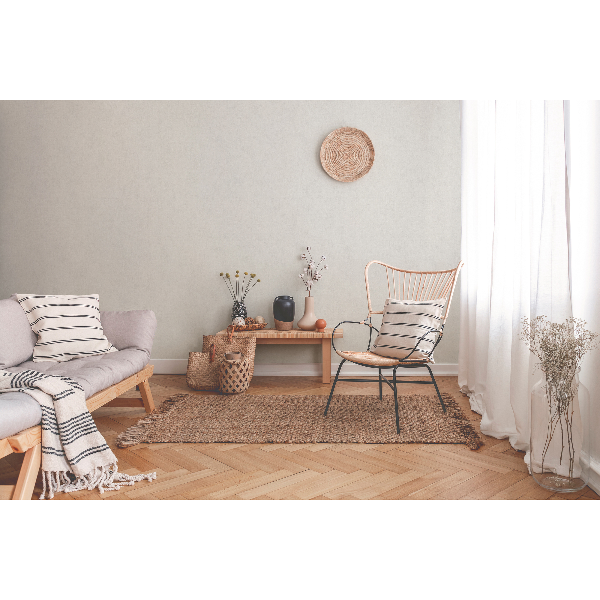 Wohnzimmer mit hellem Holzboden, Sofa, Korbsessel und Deko