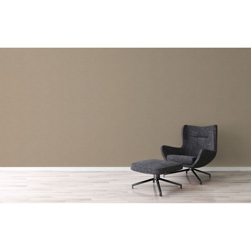 Sessel mit Fußhocker vor beiger Wand