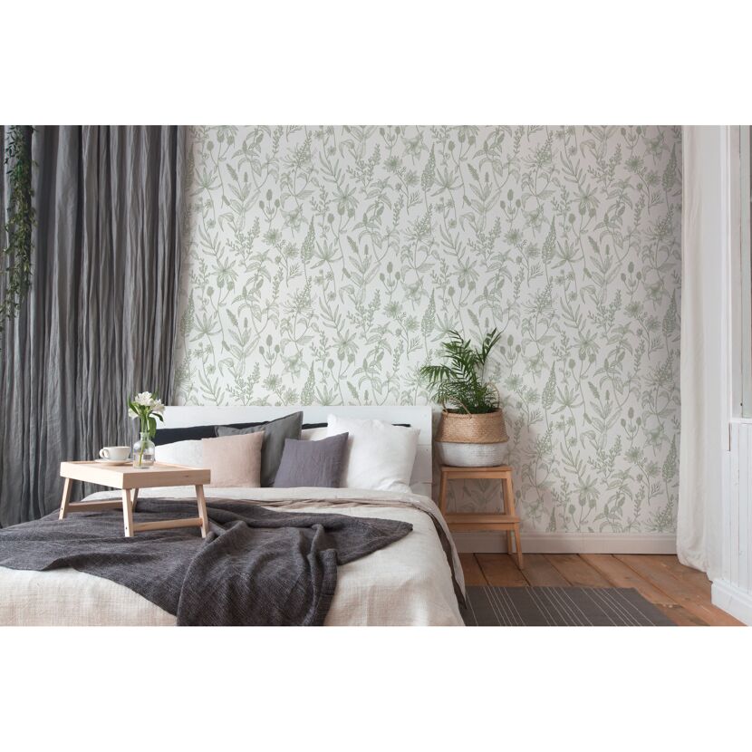 Schlafzimmer mit floral gemusterter Tapete in Grün und Weiß.