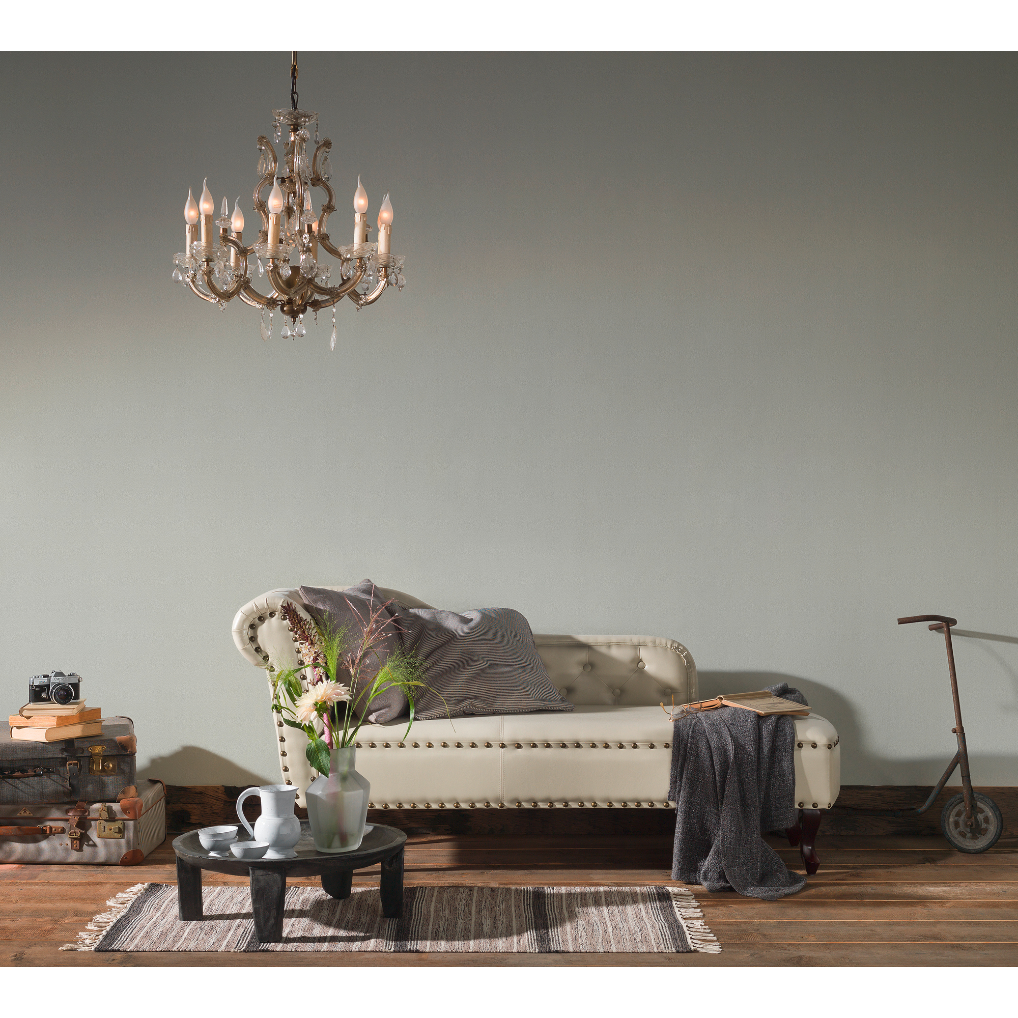 Wohnzimmer mit Chaiselongue, Leuchter, Teppich, Beistelltisch und Deko