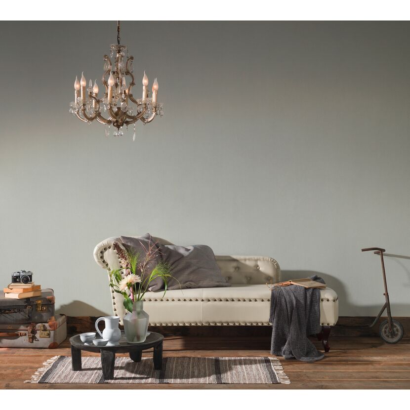 Wohnzimmer mit Chaiselongue, Leuchter, Teppich, Beistelltisch und Deko