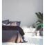 Gemütliches Schlafzimmer mit Bett, Nachttisch und Pflanze