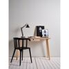 Schreibtisch mit Lampe, schwarzem Stuhl und Bildern