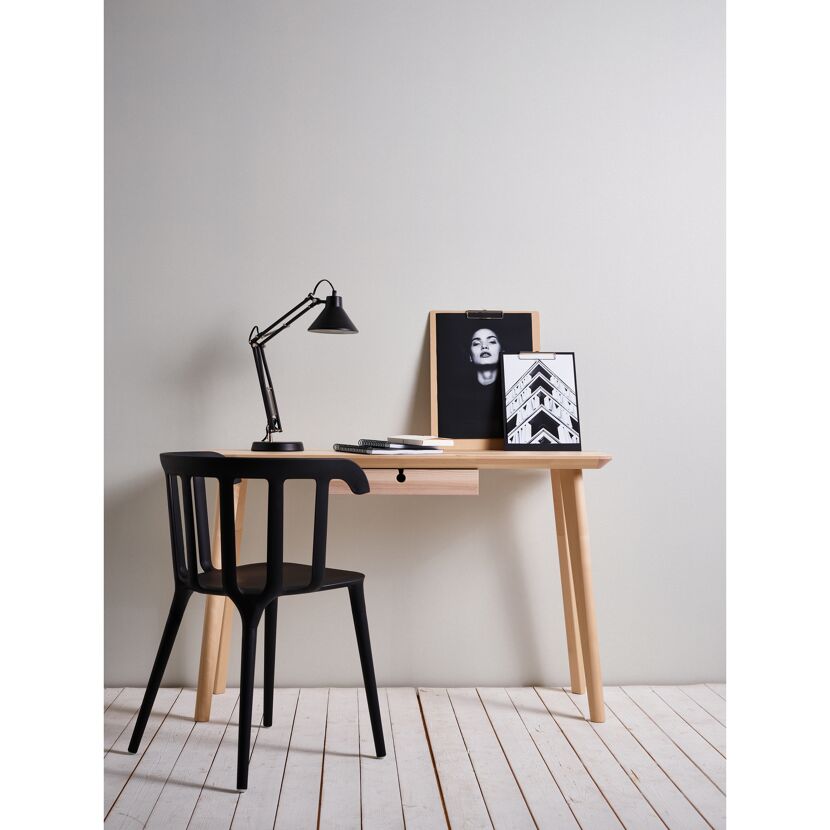 Schreibtisch mit Lampe, schwarzem Stuhl und Bildern