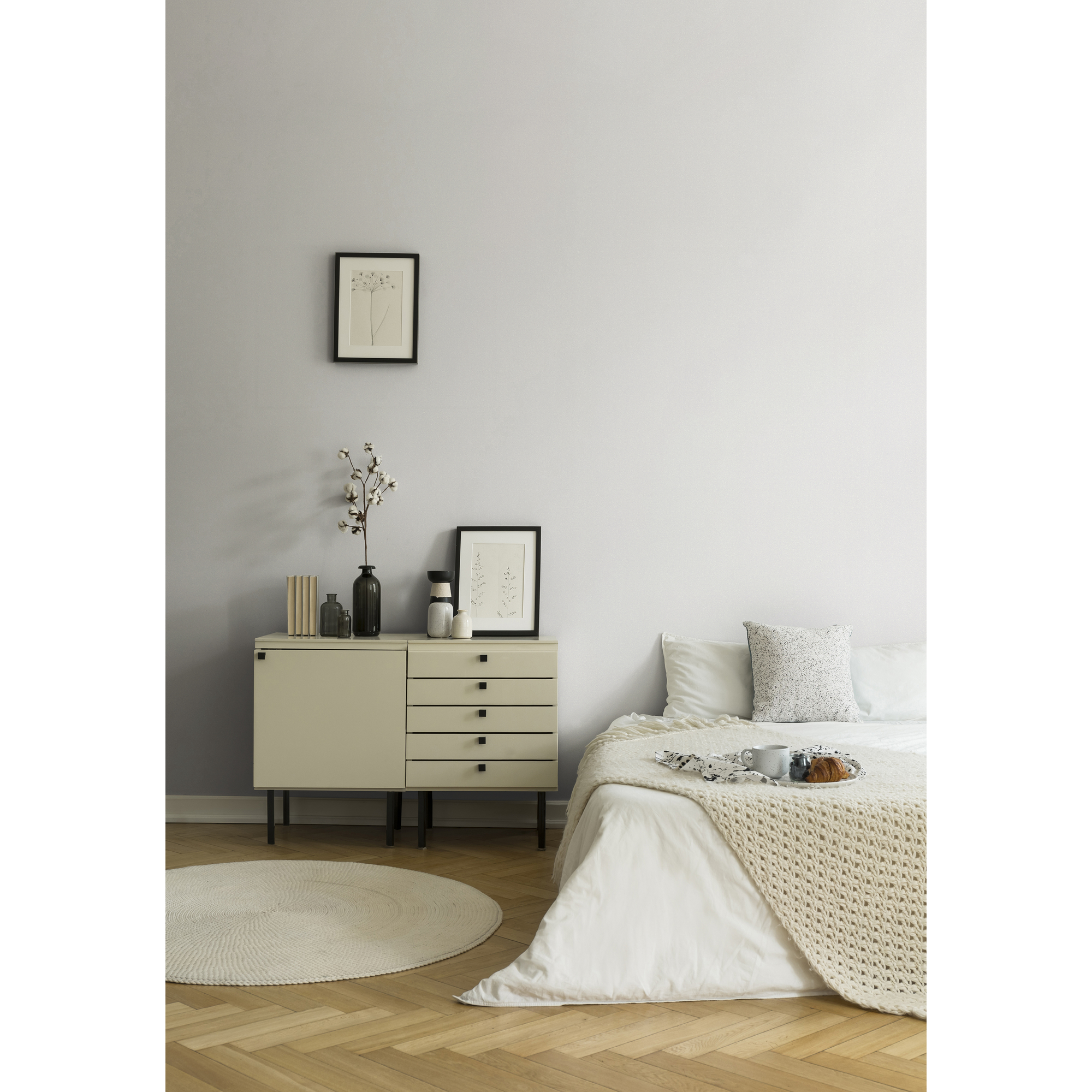 Modernes Schlafzimmer mit hellem Bett, Kommode und Deko