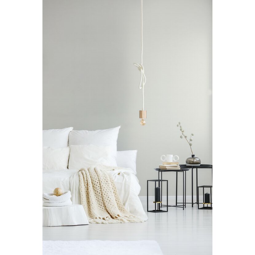 Helles Schlafzimmer mit weißem Bett und Strickdecke