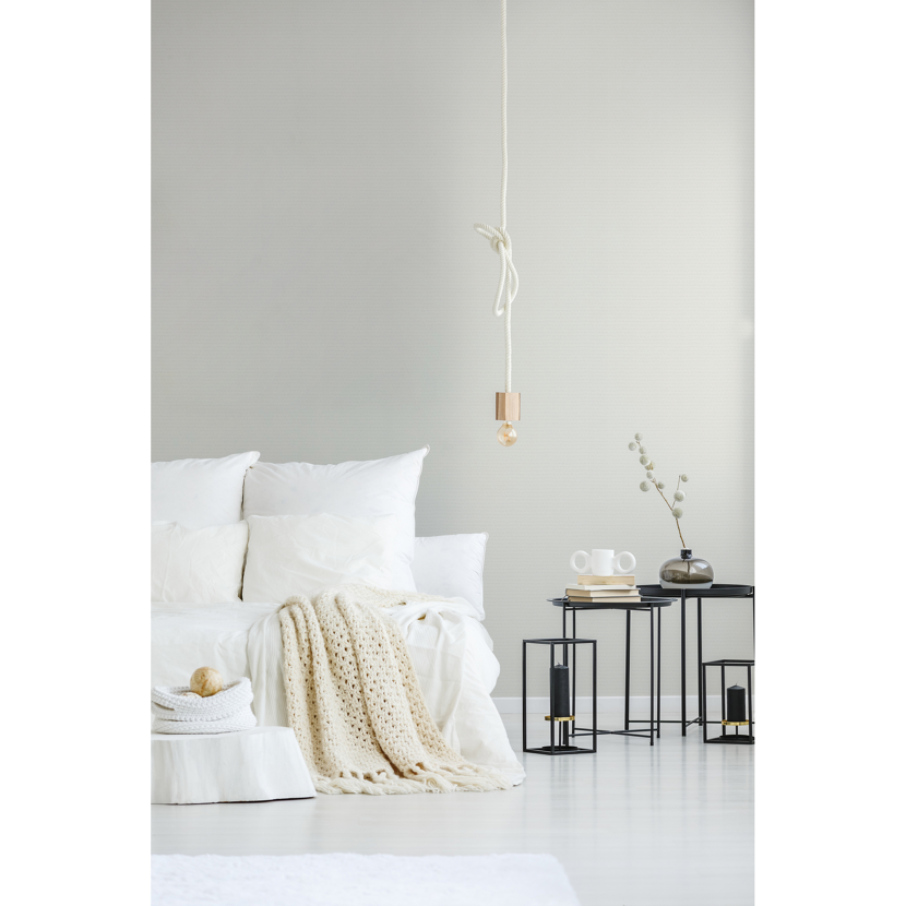 Helles Schlafzimmer mit weißem Bett und Strickdecke