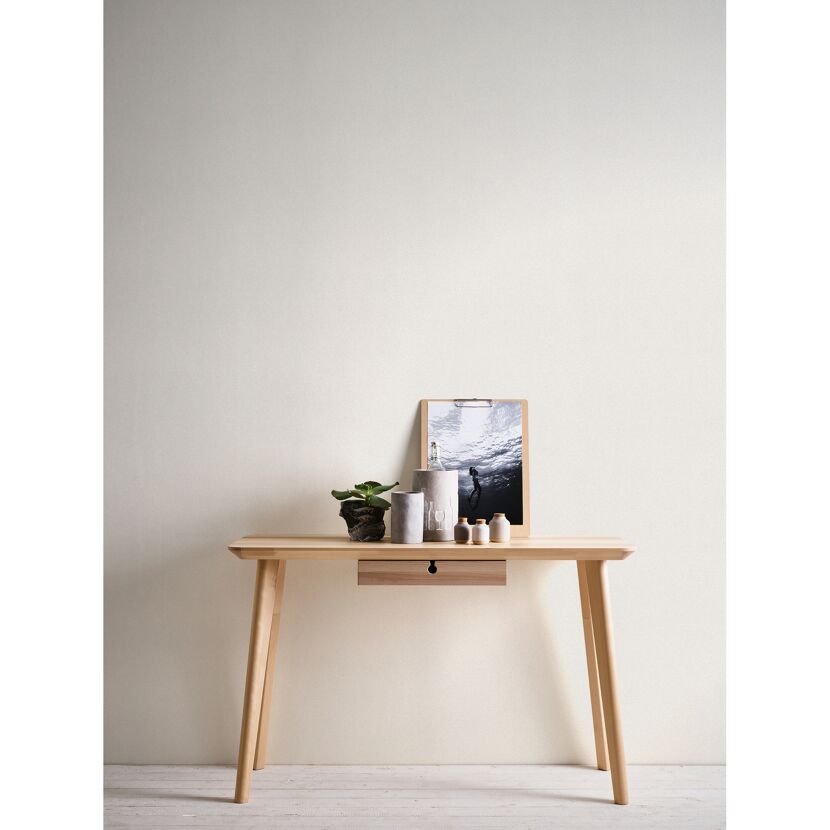 Heller Holztisch mit Dekoartikeln und Bild an einer Wand.