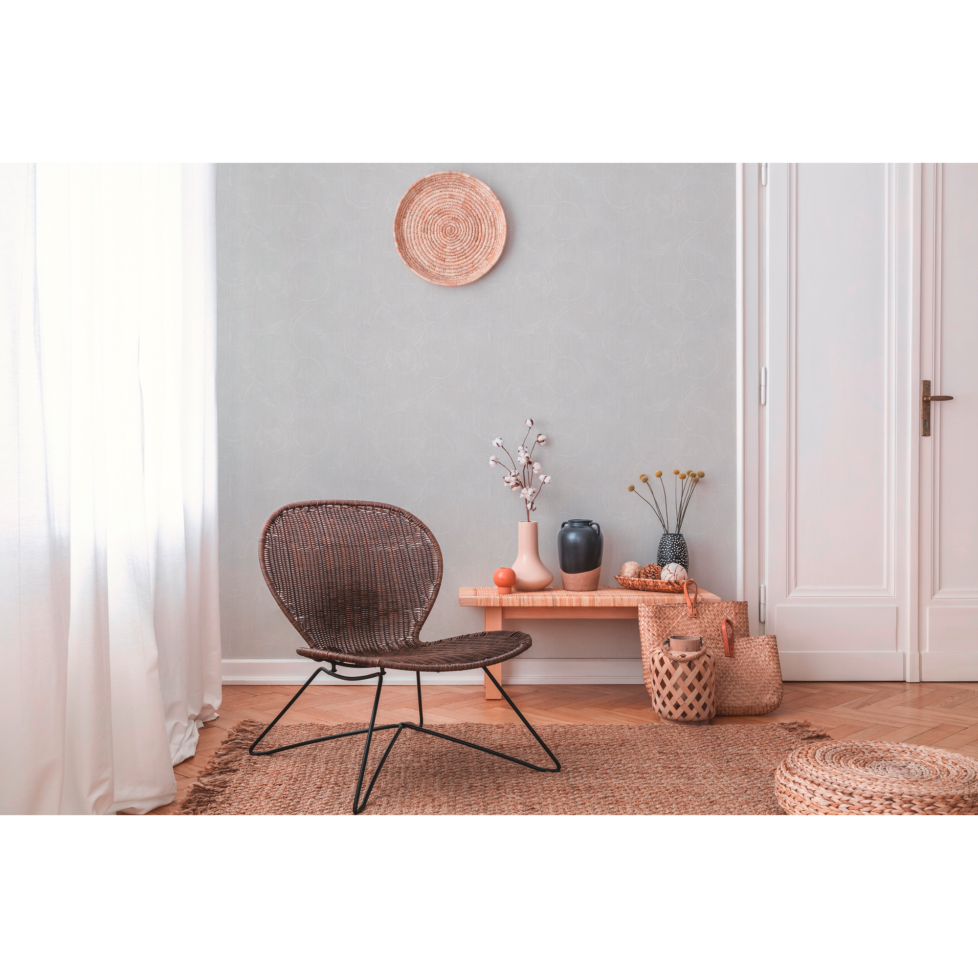 Wohnzimmer mit braunem Korbstuhl und Deko-Artikeln