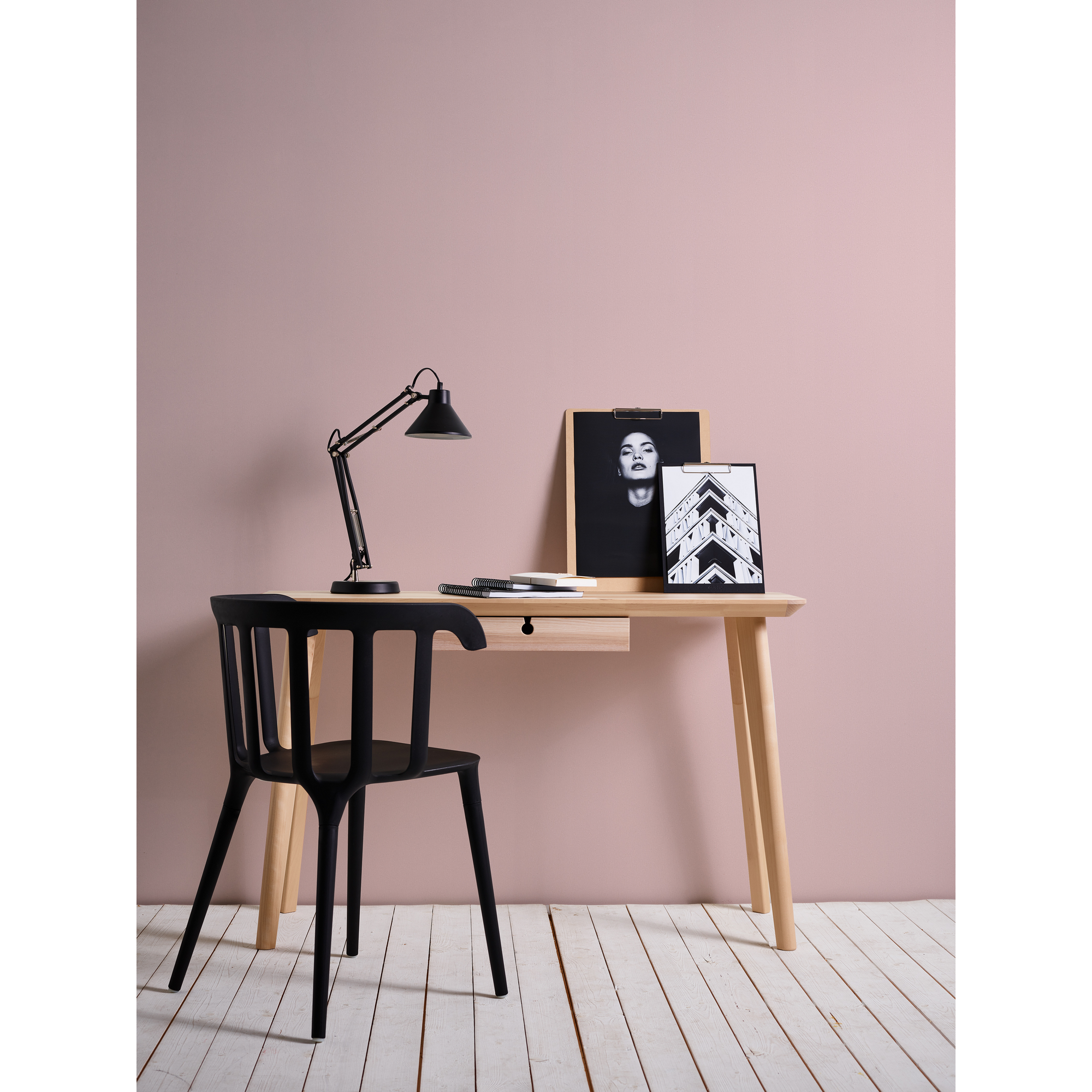 Schreibtisch mit Lampe, schwarzem Stuhl und Bildern