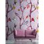Rosa Sofa vor Wandtapete mit buntem Vogelmotiv