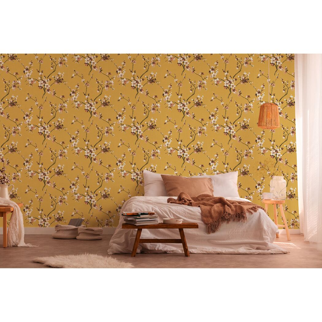 Schlafzimmer mit gelb-floral gemusterter Vliestapete