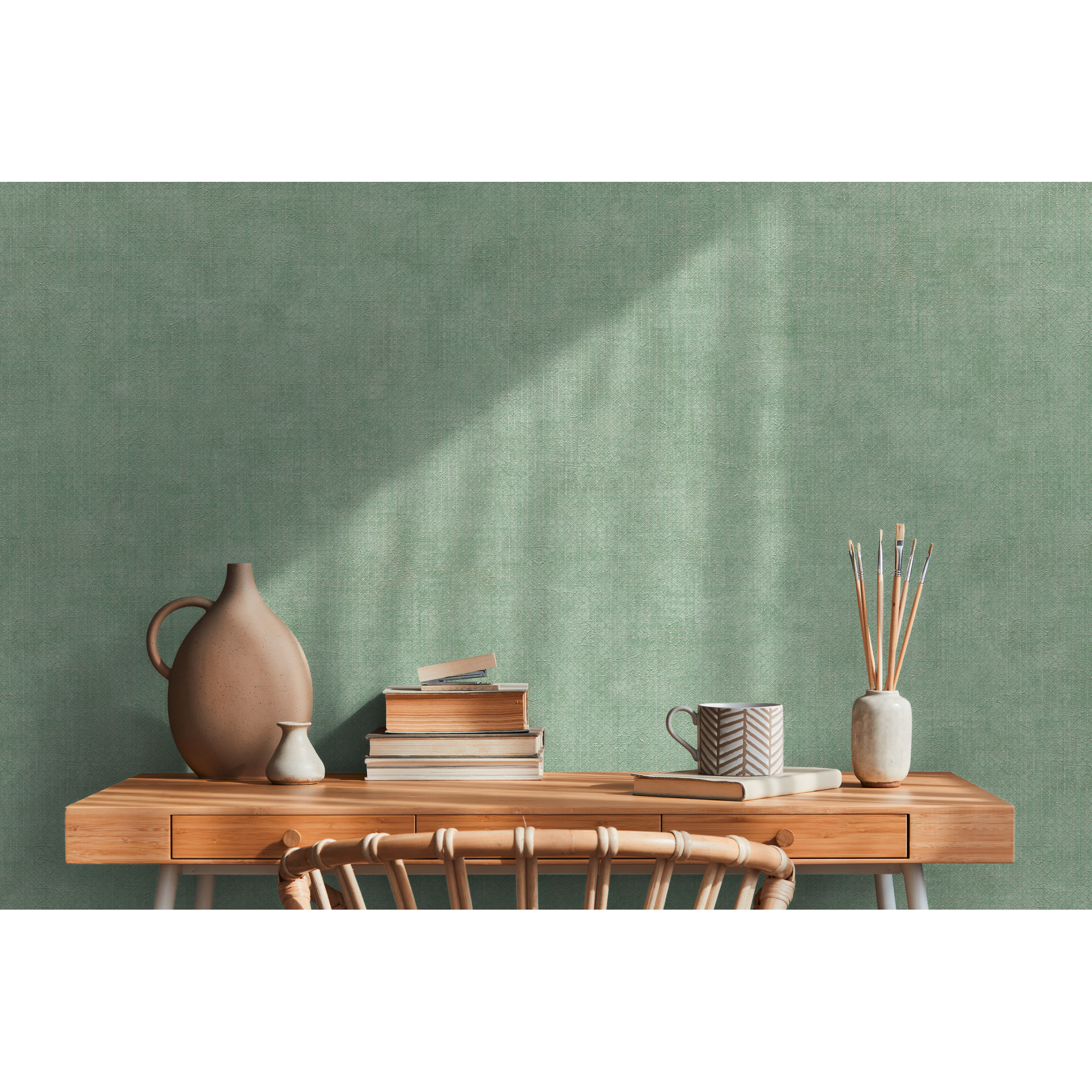 Grünes Arbeitszimmer mit Bücherstapel, Vase und Pinseln.