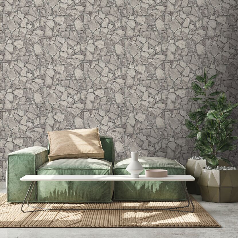 Grünes Sofa vor Bruchsteinwand